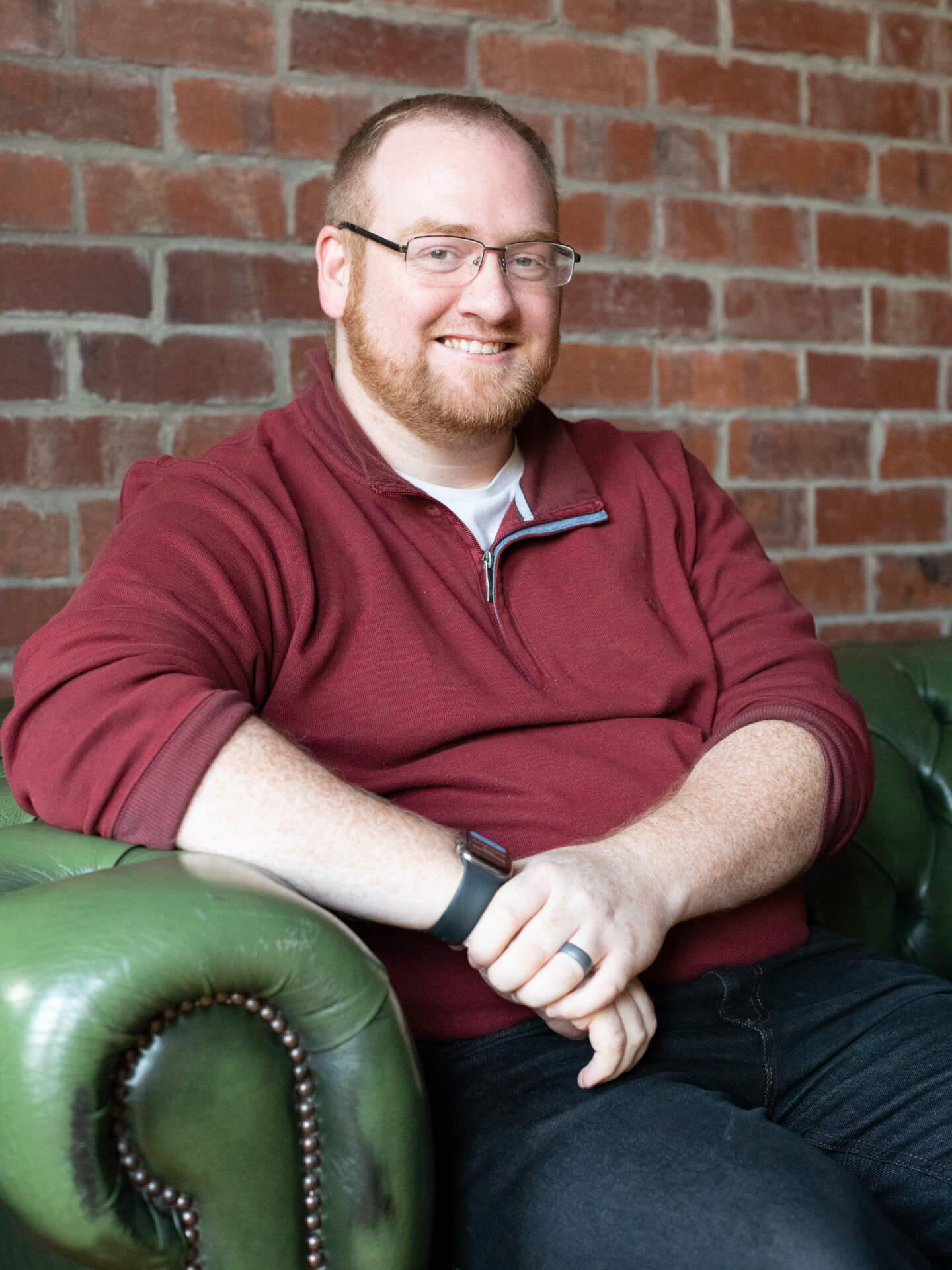 Stephen Fowles-White smiling whilst sitting on a chair